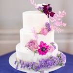Gâteau de mariage recouvert de pâte à sucre blanche et décoré de fleurs naturelles.