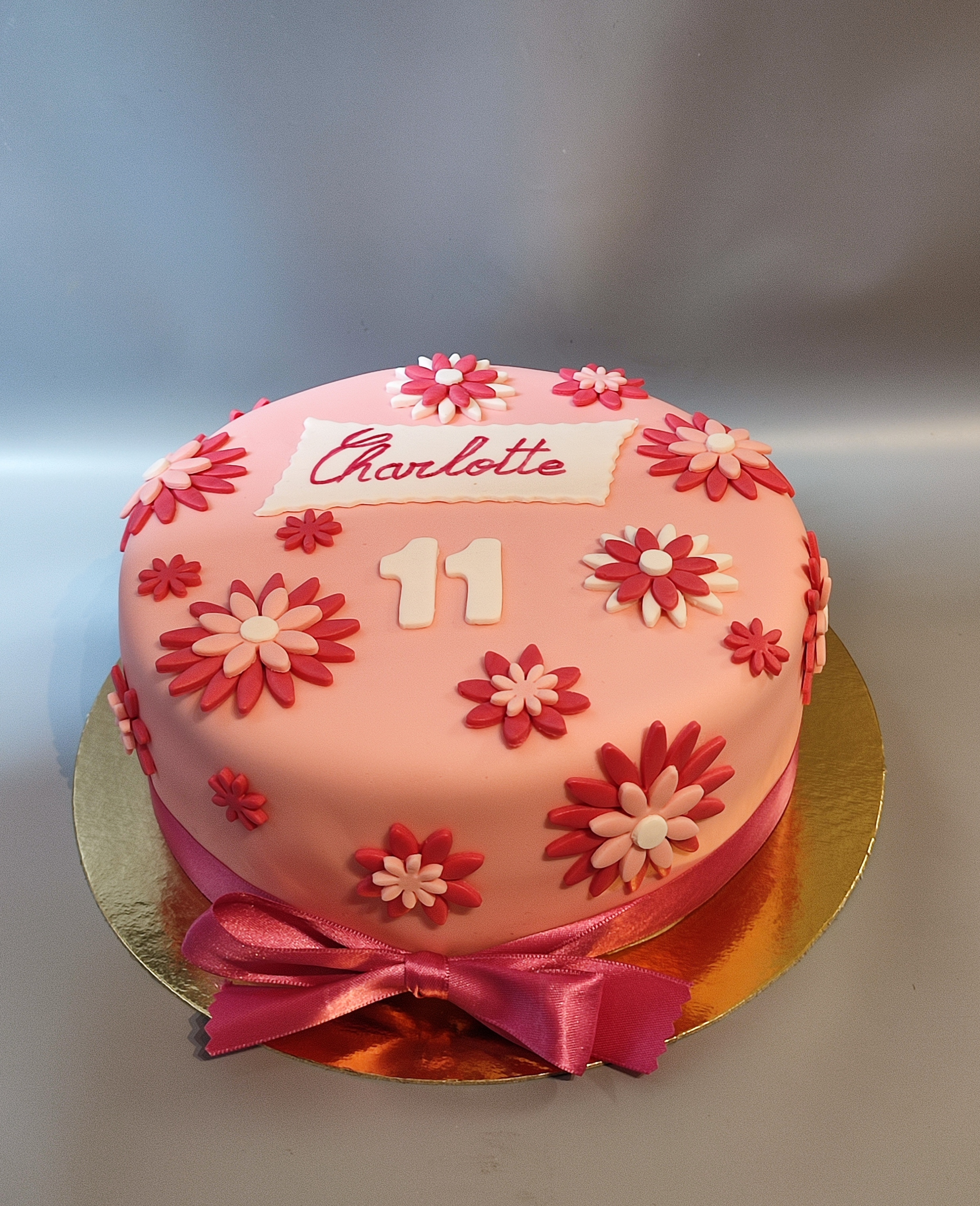 Gâteau rose à fleurs, ruban en satin
